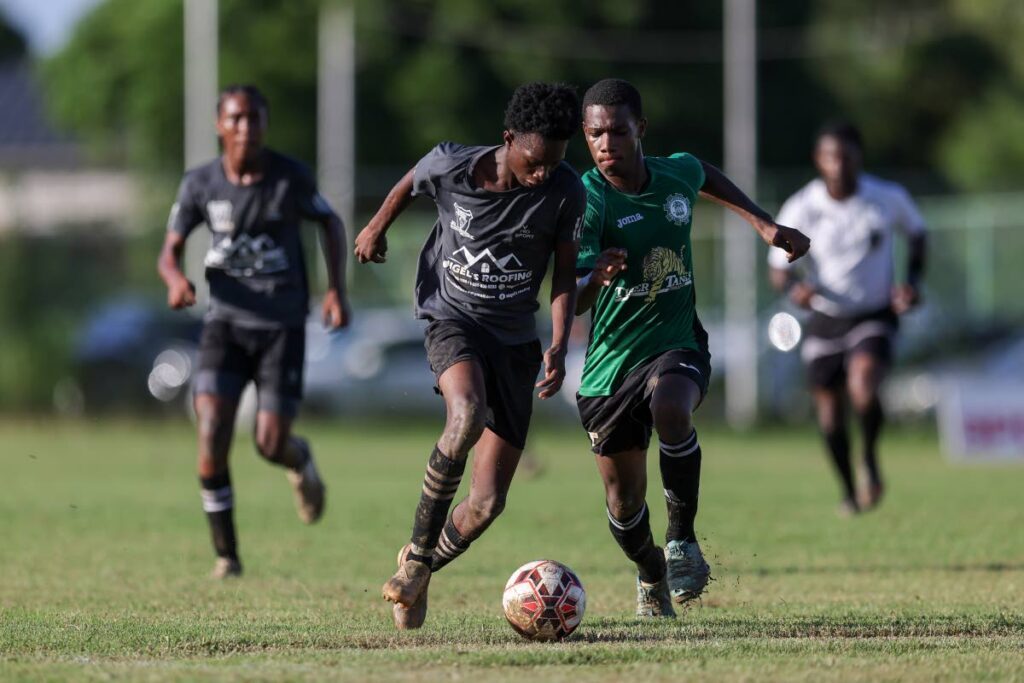 Miracle Ministries’ Kyle Holder (L) gets past Carapichaima East Rayhan Roberts during the SSFL Central Zone Intercol semifinal match at Edinburgh 500 ground on Tuesday, in Chaguanas. - DANIEL PRENTICE