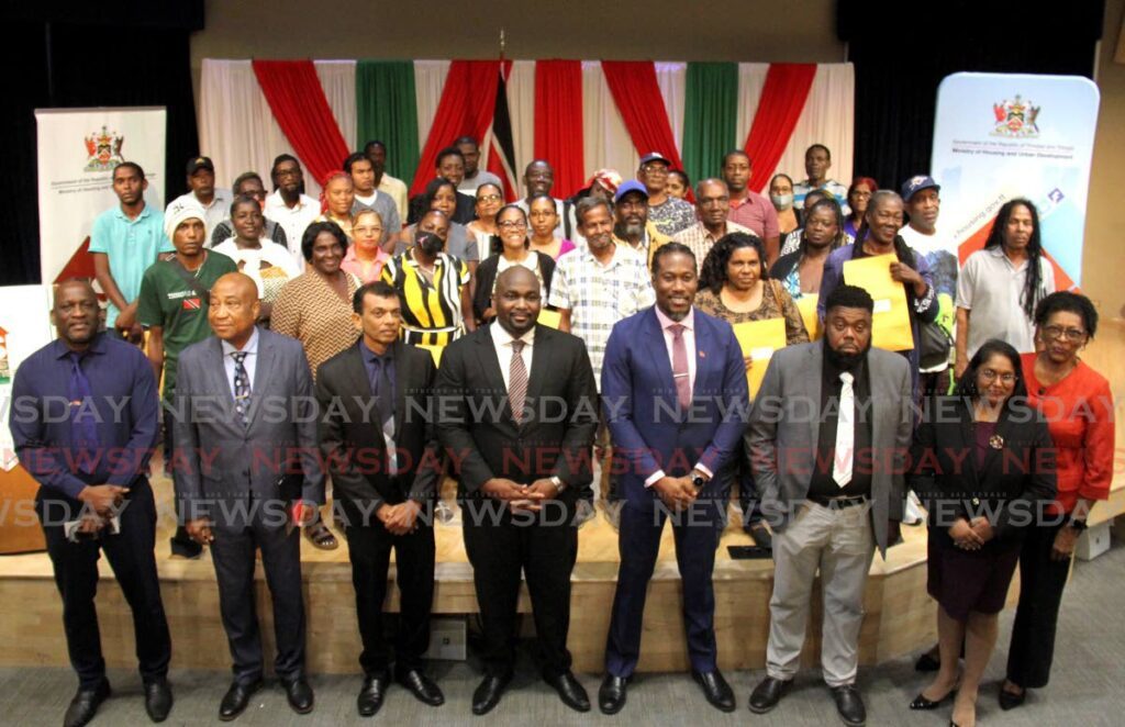 Minister in the Ministry of of Housing and Urban Development Adrian Leonce, fourth from right, takes a photo with recipients during the key distribution of starter homes under the Ministry’s Housing and Village Improvement Programme (HVIP) at Government Campus Plaza Auditorium, Port of Spain. - Photo by Ayanna Kinsale