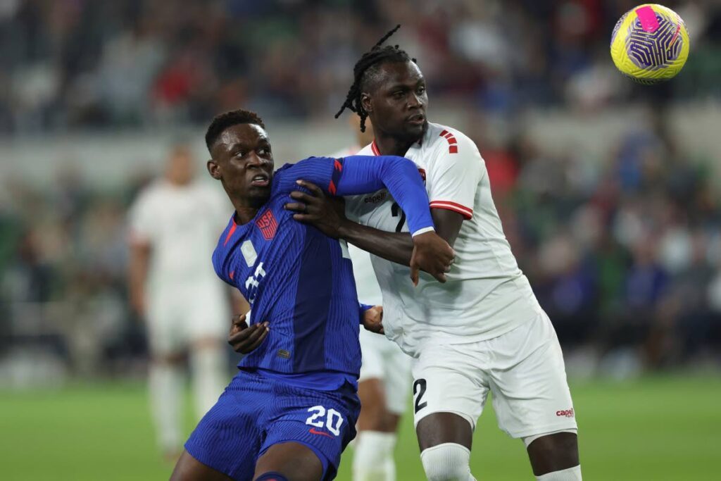 TUSSLE: US forward Folarin Balogun (20) and Soca Warriors defender Aubrey David battle for possession of the ball during the first half of the first leg of the Nations League quarterfinal on Thursday in Austin, Texas. AP PHOTO  - Stephen Spillman