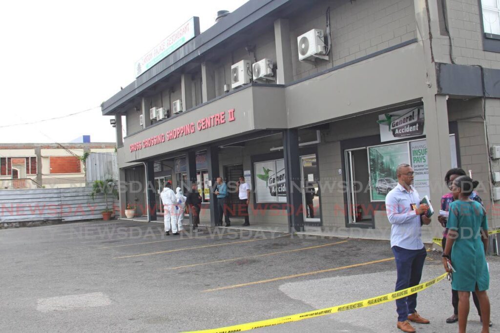 Police at the scene of a shooting in which a woman was wounded and a Rosario Ramdhan, 24, was killed at General Accident Insurance's office at Cross Crossing, San Fernando, on Monday. - Lincoln Holder