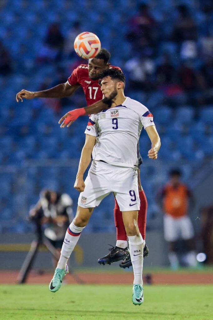 Trinidad and Tobago defender Justin Garcia (17) and USA’s Ricardo Pepi battle for a header during the Concacaf Nations League second round quarter-final match, on Monday, at the Hasely Crawford Stadium, Port of Spain.  - DANIEL PRENTICE