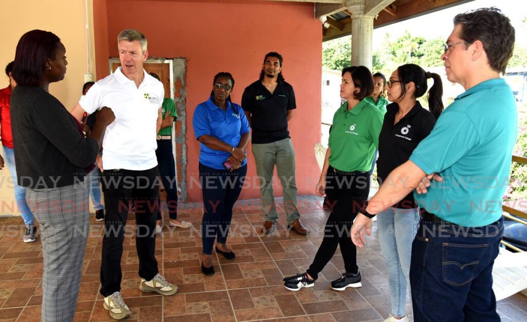 David Campbell (second from left), president, bpTT,speaking with MIPED client and owner of M&N Leisureville Oasis Beach House, Nathalie Humphrey-Alfred (left). - 
