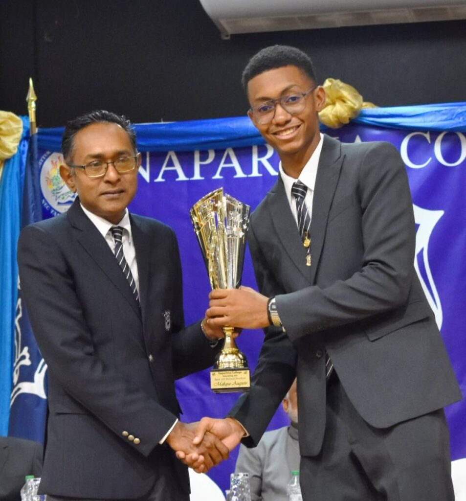 Principal of Naparima College Roger Ali, left,  presents  a trophy to Malique Auguste for his academic success  at the school's prize giving ceremony on October 19.  - Photo courtesy Malique Auguste