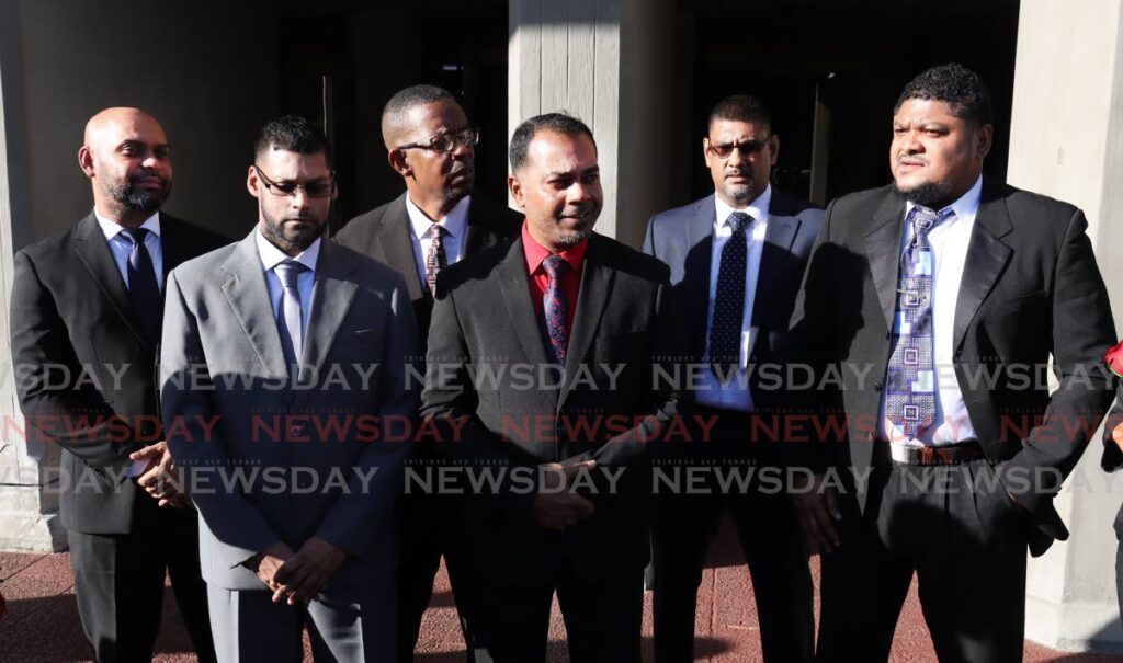 FREE MEN: At centre, Cpl Khemraj Sahadeo, is flanked by his colleagues, from left, PCs Antonio Ramadhin, Saffraz Juman, Roger Nicholas, Sgt Glenn Singh, and PC Renaldo Reviero, as he speaks to the media at the Hall of Justice, Port of Spain, after they were freed of the murder of three Moruga friends in 2011. - ROGER JACOB