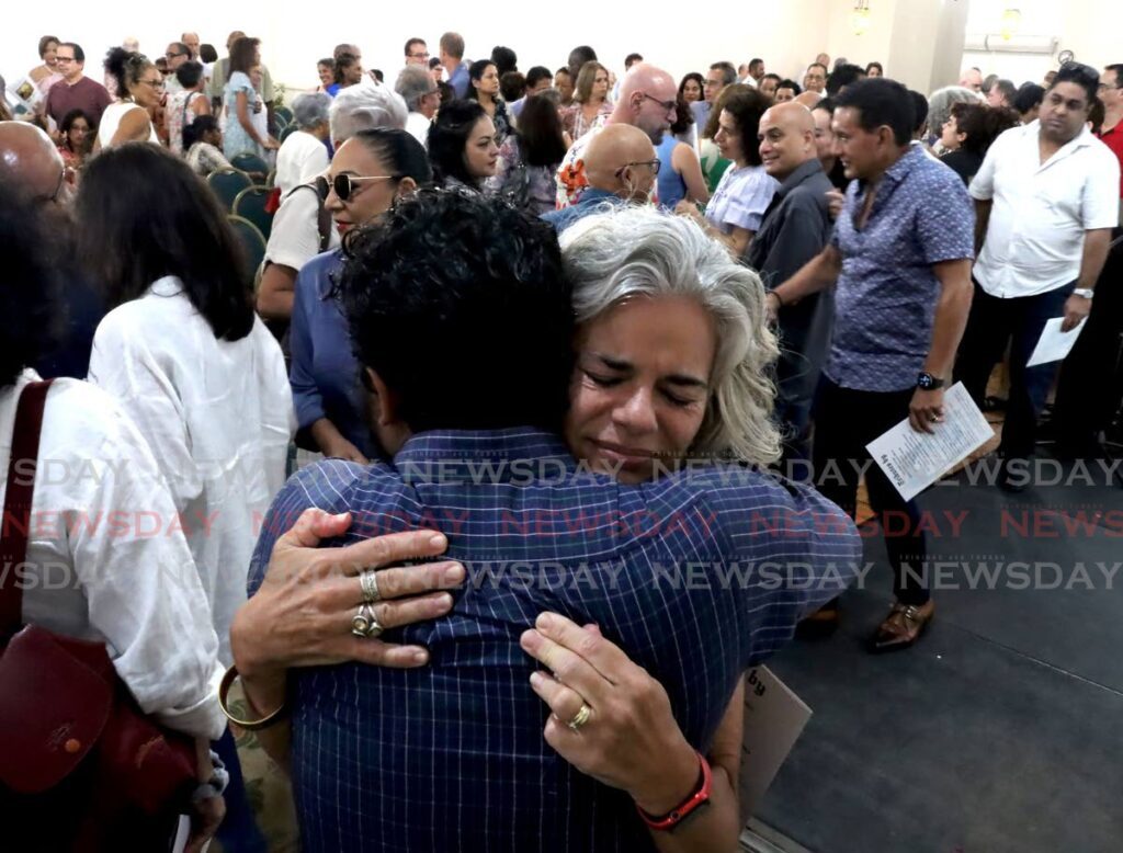 Carla Castagne, centre, is comforted at the memorial service for her husband BC Pires held at the Century Ballroom at the Queen's Park Oval in Port of Spain on Saturday. - ROGER JACOB