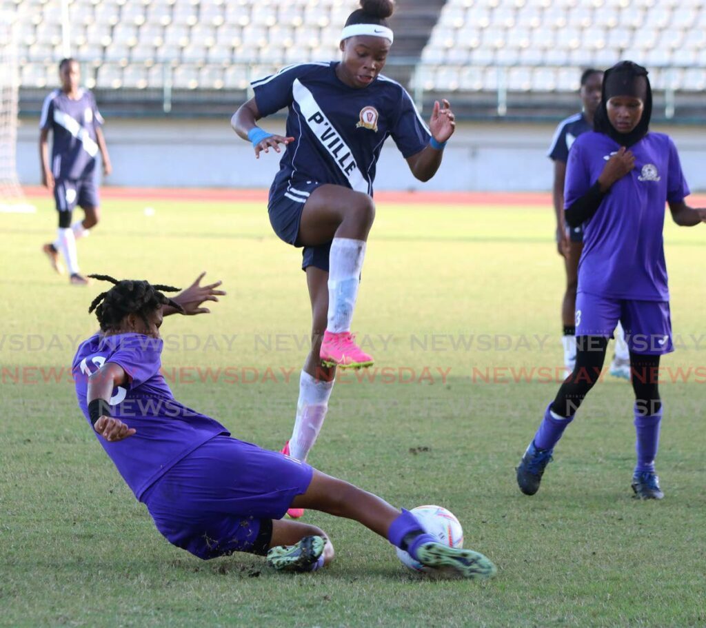 Pleasantville Secondary's Nikita Gosine skips over the tackle of Luann Craig of Five Rivers Secondary School in their Coca-Cola girls intercol quarter-final, at the Larry Gomes Stadium. Arima on Wednesday.  - Photo by Angelo Marcelle