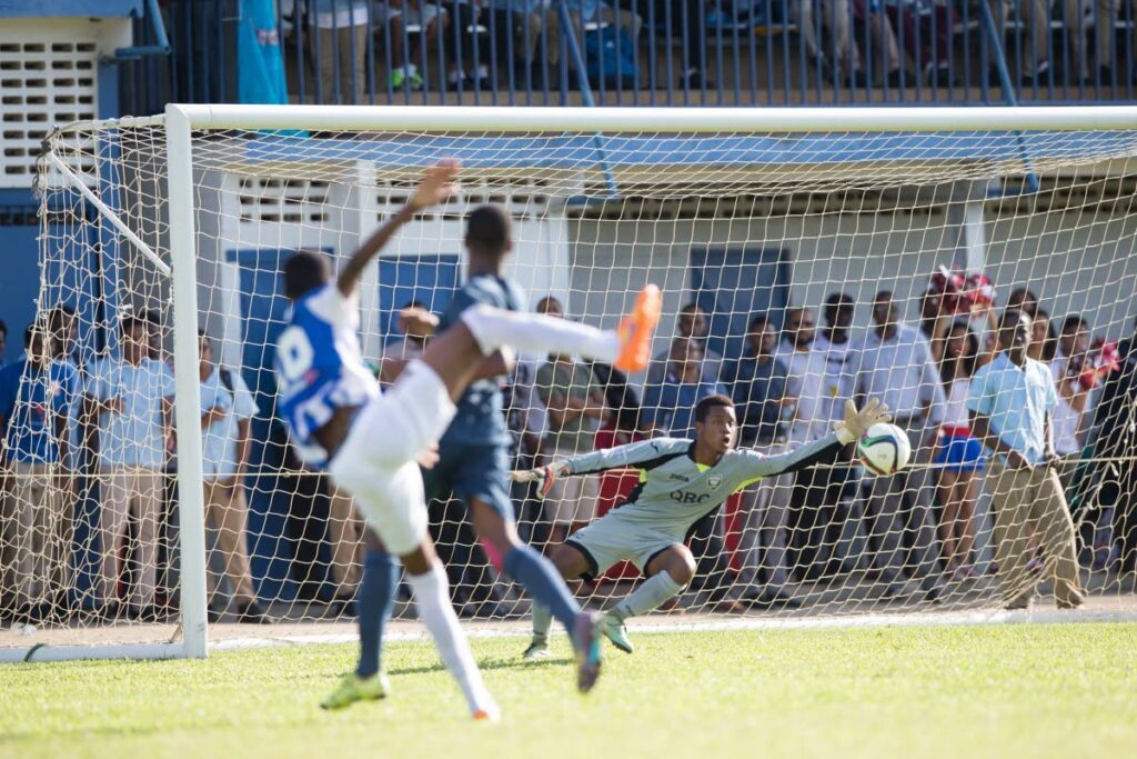 In this September 21, 2016 file photo, St Mary’s Tyrese Spicer, left, scores past a diving Queen’s Royal College goalie Kern Thomas in a Secondary Schools Football League Premeirship match at Serpentine Road, St Clair. - File Photo