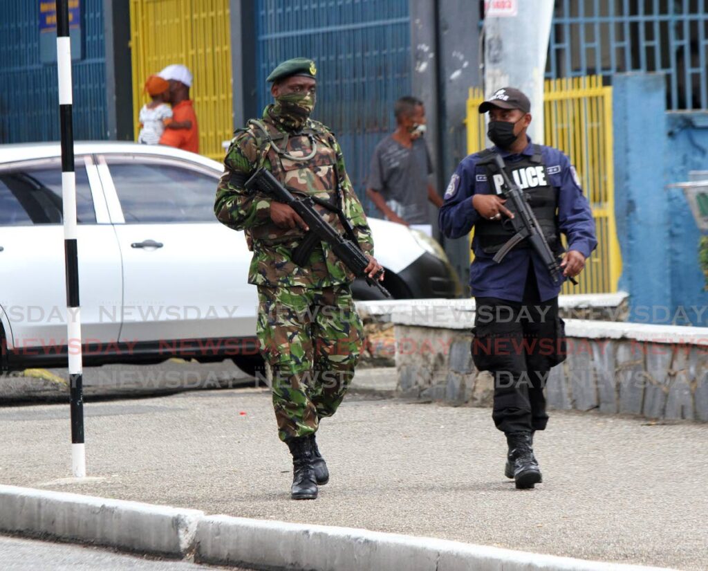 In this file photo, a soldier accompanies a police officer during a patrol in Arima.  - Angelo Marcelle