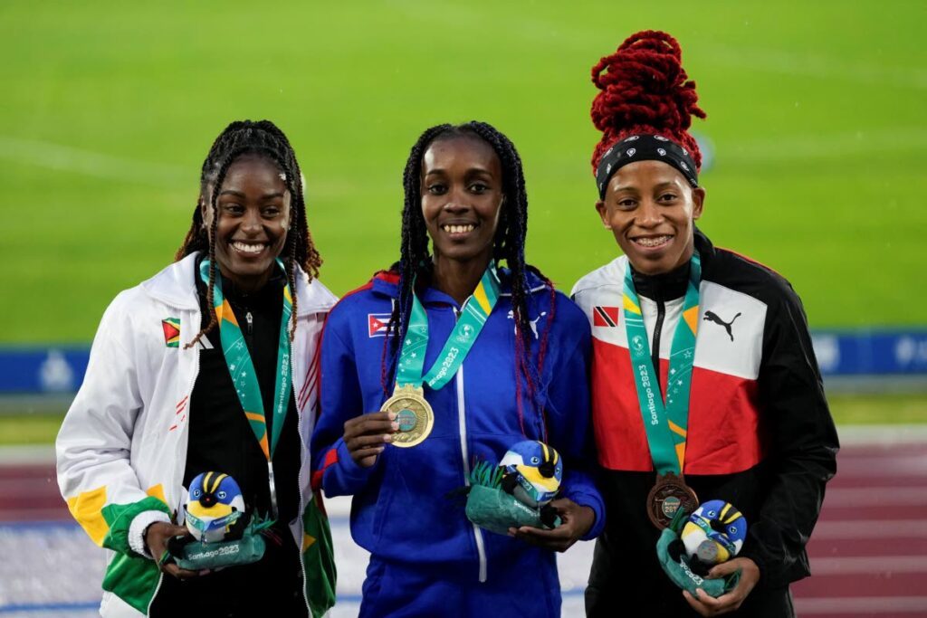 Medallists, from left, Guyana's Jasmine Abrams, silver, Cuba's Yunisleidy Garcia, gold, and Trinidad and Tobago's Michelle-lee Ahye, bronze, pose on the podium of the women's 100-meter event at the Pan American Games in Santiago, Chile, on November 1, 2023. - AP PHOTO