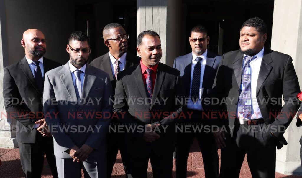At centre, Sgt Khemraj Sahadeo, is flanked by his colleagues, from left, PCs Antonio Ramadhin, Saffraz Juman, Roger Nicholas, Glenn Singh, and Renaldo Reviero, on November 24, after  they were freed of the murder of three Moruga friends in 2011. - ROGER JACOB