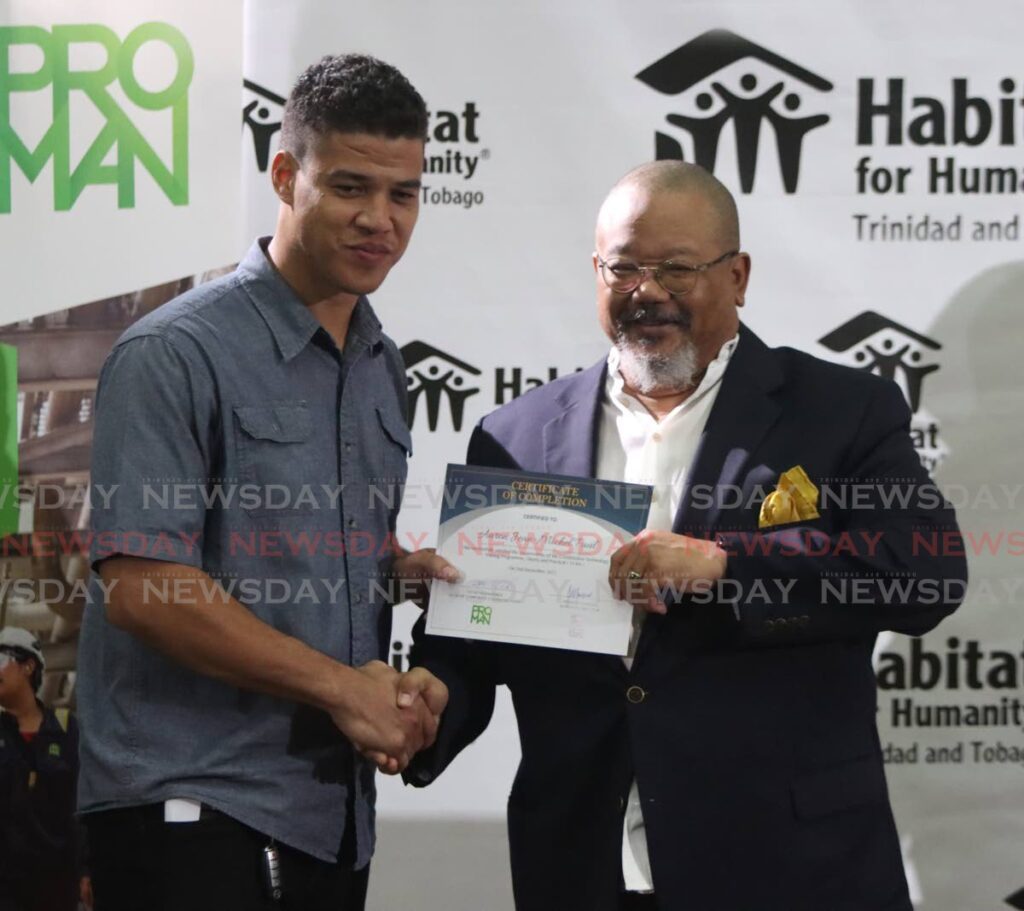 Habitat for Humanity TT chairman Derwin Howell, right, presents Aaron Jean-Michael Paul, with his certificate of completion in the construction technology training, at UWI St Augustine campus on Saturday. - Angelo Marcelle