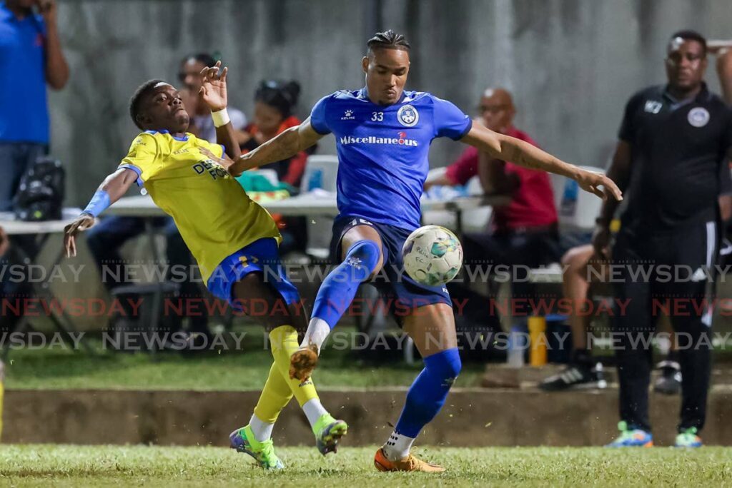 Police FC defender Alvin Jones, right, holds off Defence Force's Kaihim Thomas during a TT Premier Football League match at the Police Barracks, St James on Sunday. - Photo by Daniel Prentice