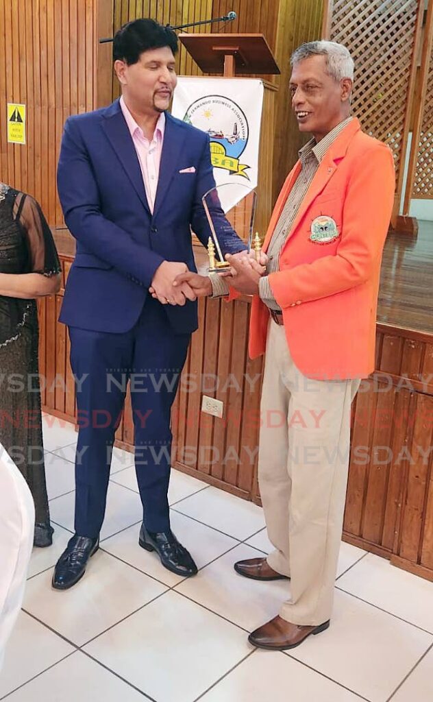Justice Frank Seepersad, left, presents an award to Vallence Rambharat  of the Hunters Search and Rescue team during an award function by the San Fernando Business Association at San Fernando City Hall on Saturday.  - Photo by Yvonne Webb 