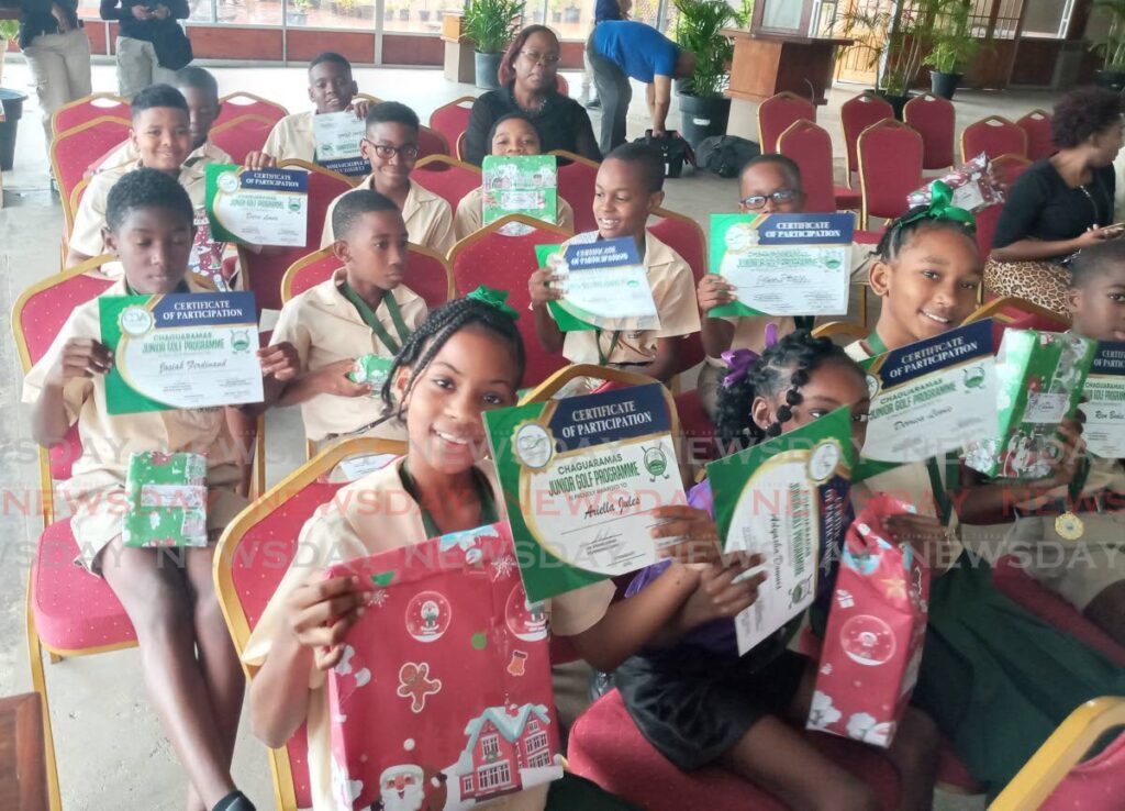 Students of St Peters RC Primary School are all smiles after receiving certificates, medals and Christmas gifts at the closing ceremony of the Chaguaramas Development Authority Junior Golf Clinic at the Anchorage, Chaguaramas on Wednesday. - Jelani Beckles