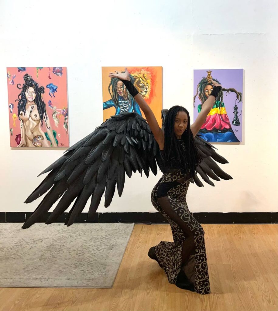 Brittany Davis poses with some of her paintings.  - 