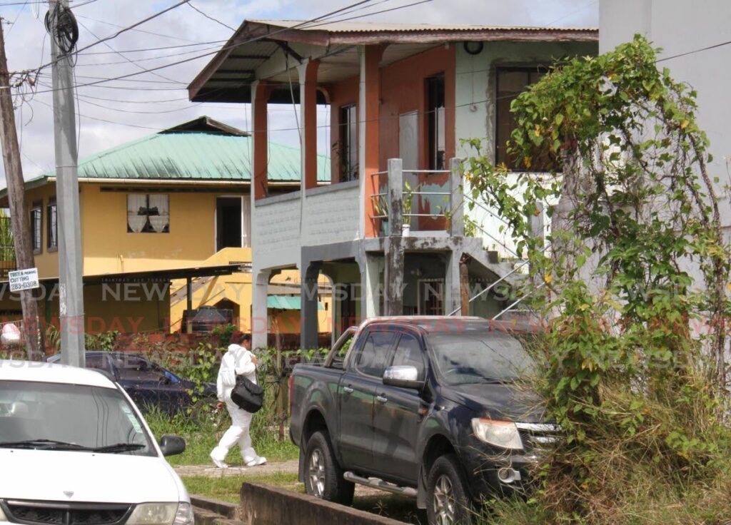 A CSI officer arrives at the Battoo Street, Marabella home where Hollice Thomas and her son Noel Thomas, eight, were found stabbed on Tuesday morning.  - Photo by Ayanna Kinsale