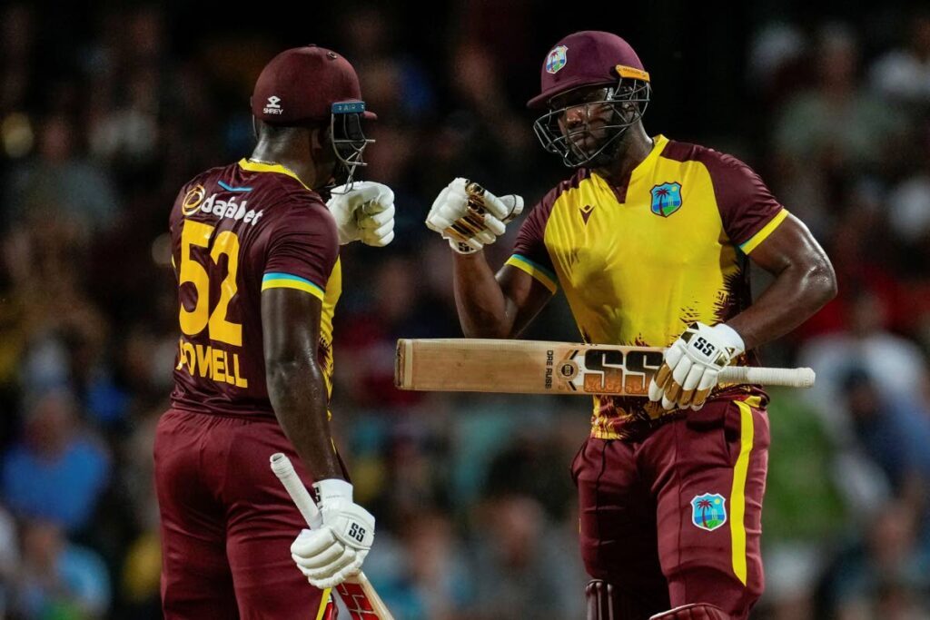 West Indies' batsmen Andre Russell and Rovman Powell celebrate runs during their partnership against England in the first T20 at Kensington Oval in Bridgetown, Barbados, on Tuesday. - AP PHOTO