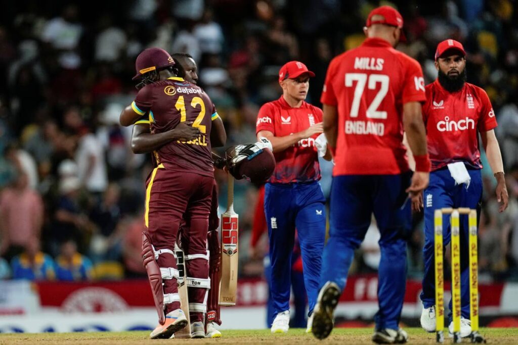 West Indies' Roman Powell and Andre Russell embrace after defeating England by four wickets in the first T20 at Kensington Oval in Bridgetown, Barbados, on Tuesday. - AP PHOTO