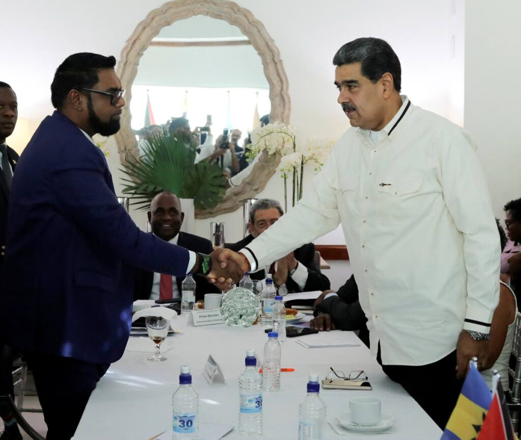 This handout picture released by the Venezuelan Presidency shows Venezuela's President Nicolas Maduro, right, shaking hands with Guyana's President Irfaan Ali during a meeting in St Vincent and the Grenadines on December 14, 2023.   - AFP