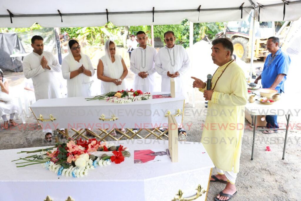 Pundit Dayanand Maharaj at the funeral of Surujdai Soogrim, 92, and son Boysie Sonnyboy, 63, on Saturday at Barrackpore. The mother and son died in house fire in New Grant on December 10.  - Jeff K. Mayers