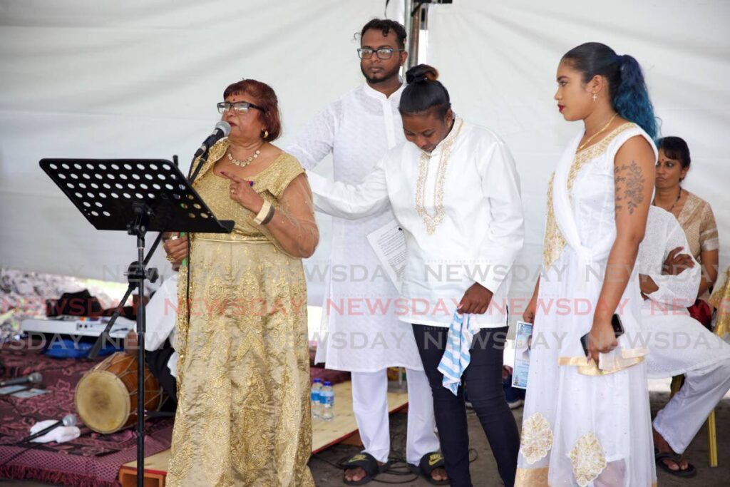 An emotional Rukmi­nee Holass-Beepath, singer and sister of deceased singer Budram Holass, speaks at his funeral at Southern Main Road, Chatham, on Sunday. - Photo by Jeff K. Mayers