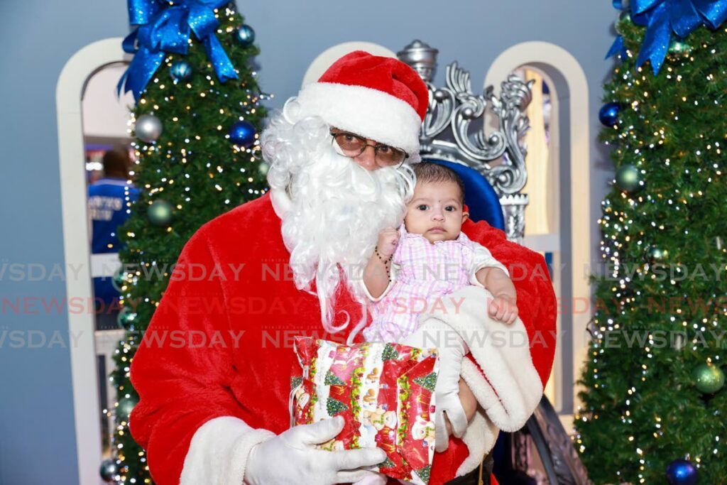 Santa Claus with three-month-old Kaylee Kimkeran of Rousillac, at the Gulf City Mall La Romain on Christmas Eve. - Photo by Jeff K. Mayers