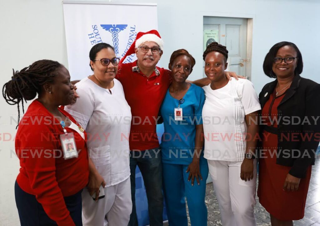 Health Minister Terrence Deyalsingh poses for a photo with registered nurses during a visit to the San Fernando General hospital on Tuesday. - Photo by Jeff K. Mayers