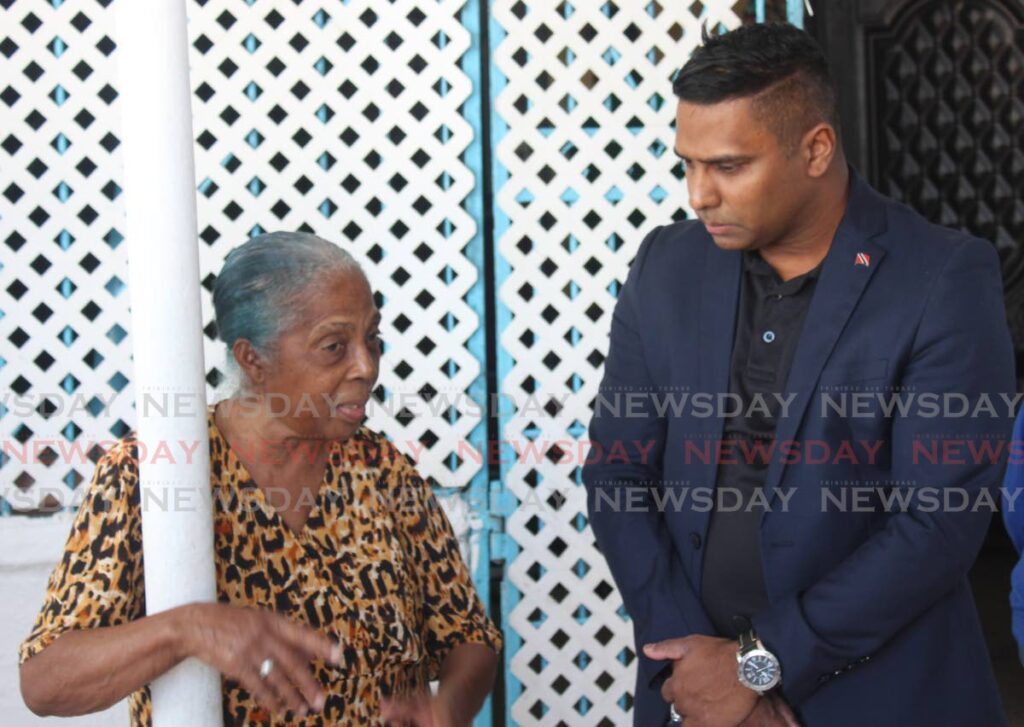 Chief Personnel Officer Commander Dr Daryl Dindial chats with Margaret Kistow after delivering Christmas goodies to the Margaret Kistow Home. - 