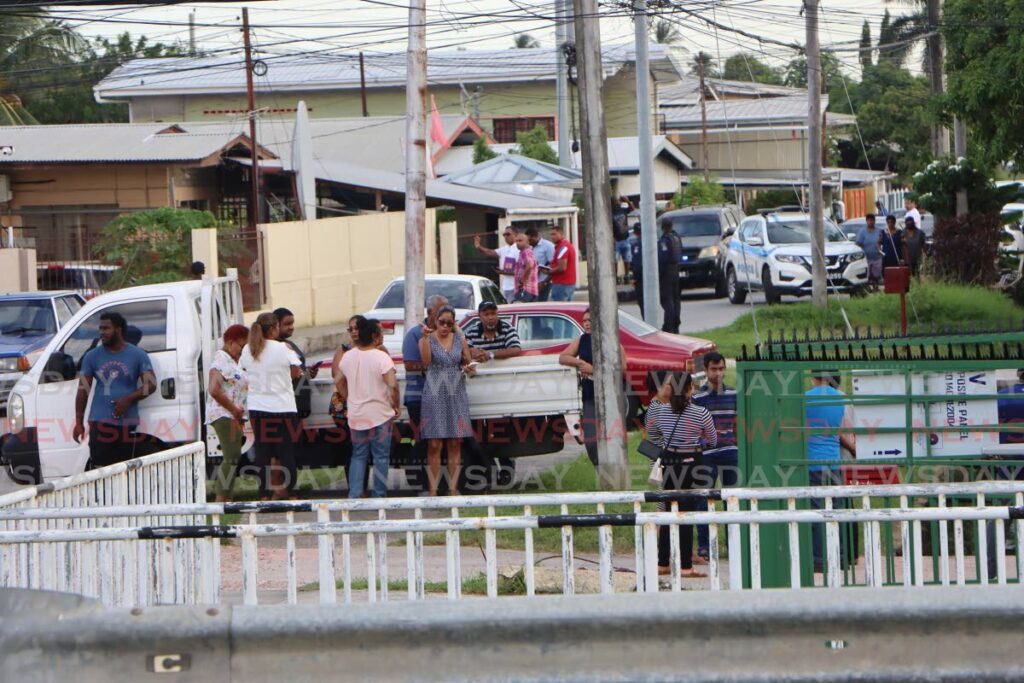 Residents of Spring Village mill around after three men and a woman were shot dead in an incident that started off the Churchill Roosevelt Highway and spilled over into the Spring Village community on Wednesday.