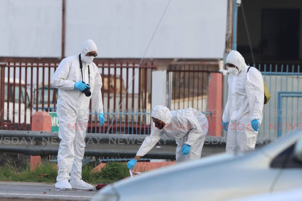 Crime Scene Investigators collect evidence on the west-bound lane of the Churchill Roosevelt Highway, near Spring Village, Valsayn, on Wednesday. - Angelo Marcelle