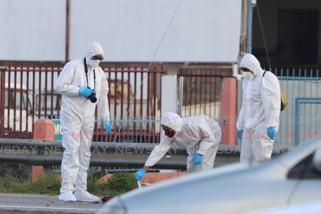 Crime Scene Investigators collect evidence on the west bound lane of the Churchill Roosevelt Highway in the
vicinity of the St Augustine Girls High School, where three men were killed in December, 2023. FILE PHOTO