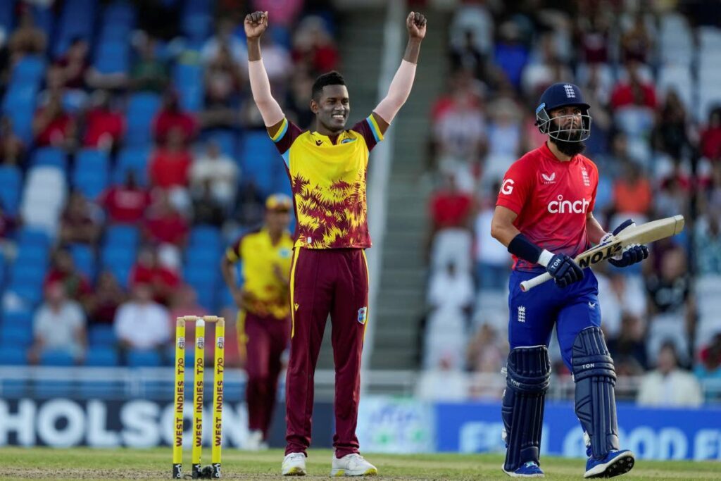 West Indies’ Akeal Hosein celebrates taking the wicket of England’s Moeen Ali, right, during the fifth T20 match at Brian Lara Stadium in Tarouba, on December 21. - AP PHOTO