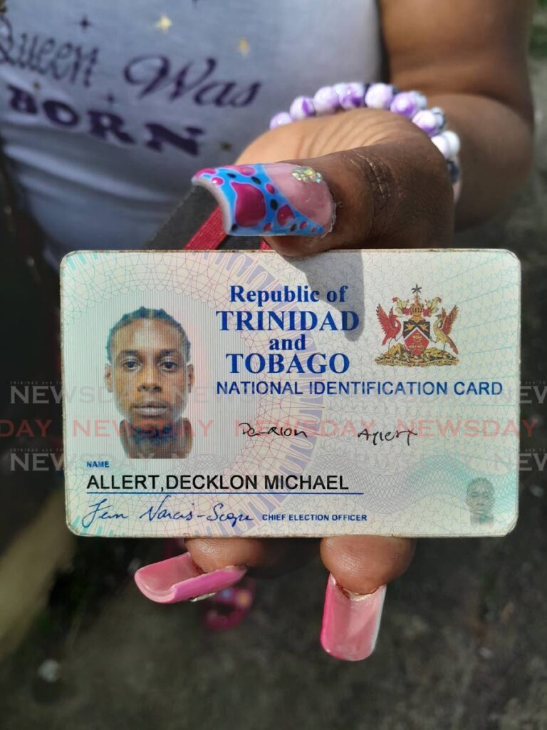A woman displays the ID card of her relative Decklon Allert who was among two men shot to death on Thursday in Diego Martin. PHOTO BY GREGORY MCBURNIE  - Gregory Mc Burnie