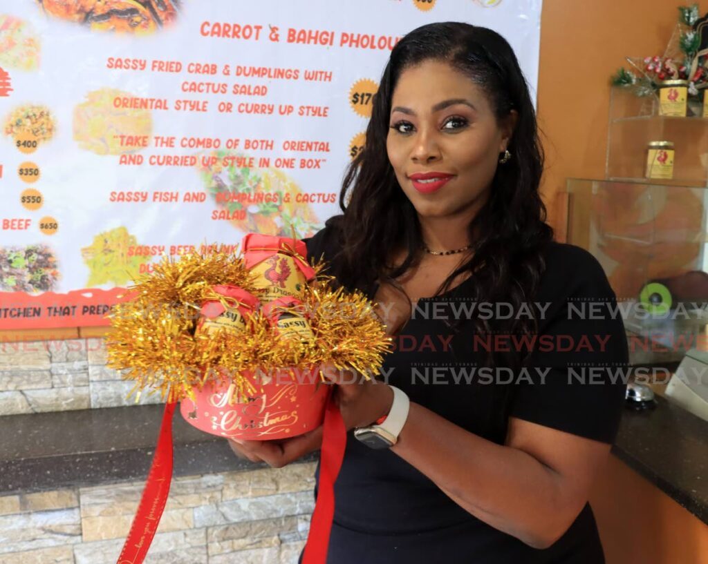 Nneka Braveboy shows off her smoked herring pepper sauce. - ROGER JACOB