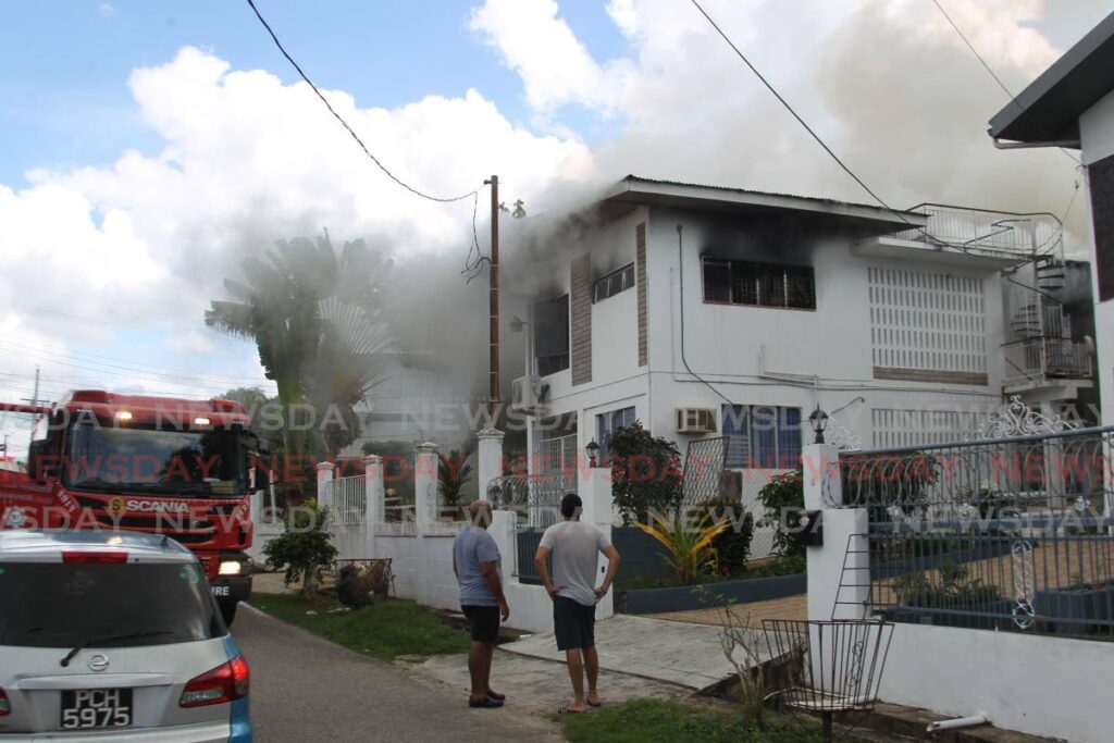 Fire officers from the Mon Repos fire station at the scene of a house fire at the corner of Pearl and Hillcrest avenue, Battoo New Lands, Marabella - Photo by Lincoln Holder