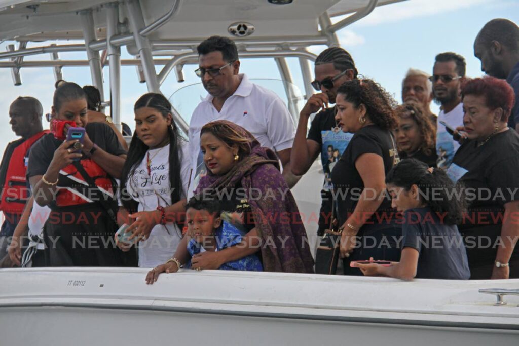 In this file photo, Vanessa Kussie, centre, and other relatives during a memorial service for her husband Rishi Nagassar at sea in 2022. - 