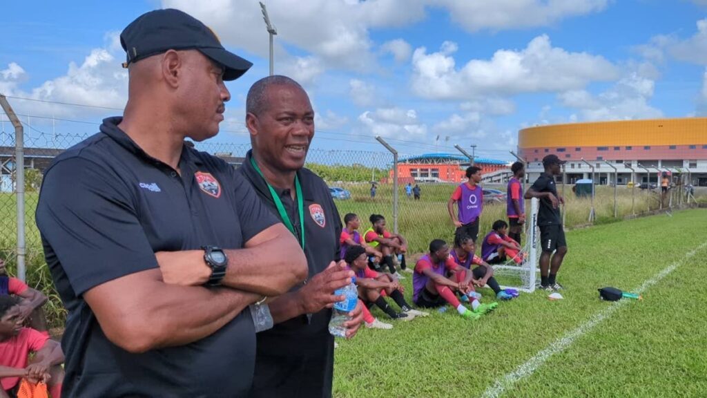 In this file photo, TT men’s under-20 football team coach Brian Haynes (R) and TT men’s under-17 football coach Shawn Cooper (L) pass on ideas during a screening session for the men’s under-20 team at the Ato Boldon Stadium training field in Balmain, Couva.  - File photo courtesy TTFA