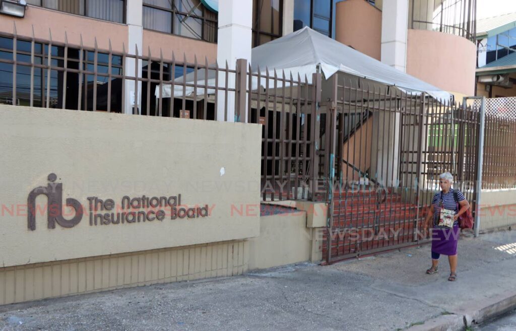 A woman walks away from a closed NIB office in Arima last Wednesday.  - Angelo Marcelle