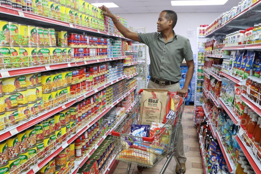 Shopper Barry Telesford fills his cart with essential food items at a grocery store in Port of Spain. - File photo by Faith Ayoung