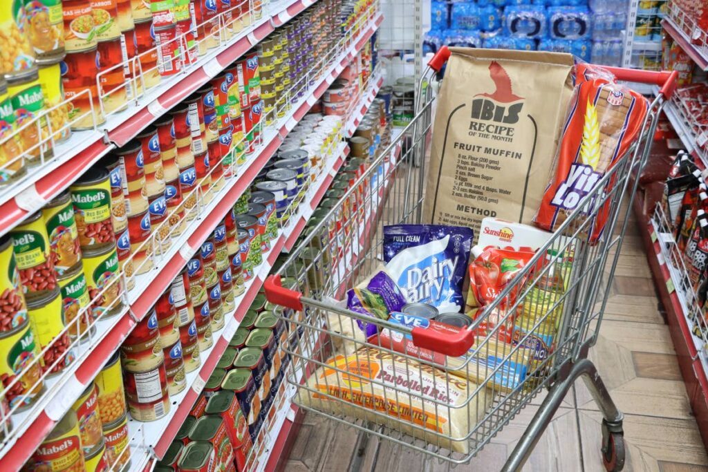 Shopping cart filled with essential food items at a grocery store in Port of Spain. - File photo bu Faith Ayoung