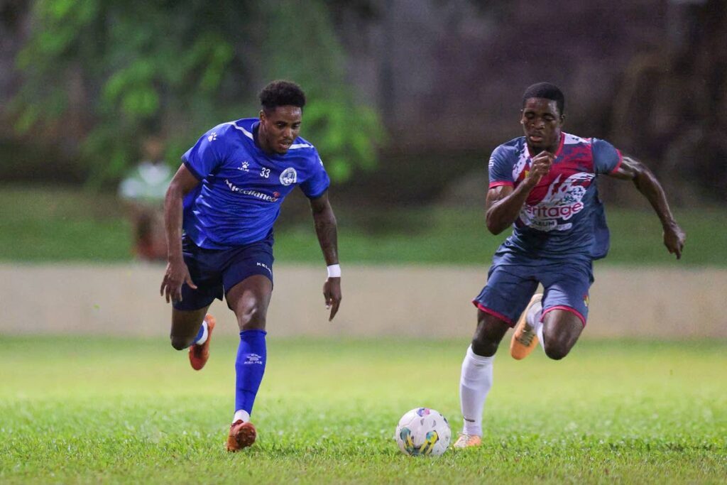  Police FC Joevin Jones (L) goes past Point Fortin Civic’s Justin Cornwall during the TT Premier Football League match at the Police Barracks on Wednesday, in St James. - DANIEL PRENTICE
