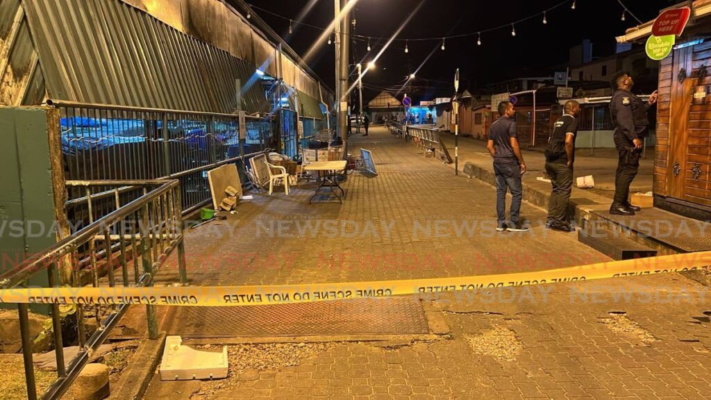 Police officers  where the access to the Tunapuna Market, between the Priority Bus Route and the Eastern Main Road, was cordoned off after five people were shot, two of them fatally, on Wednesday night. - Photo by Jeff K Mayers