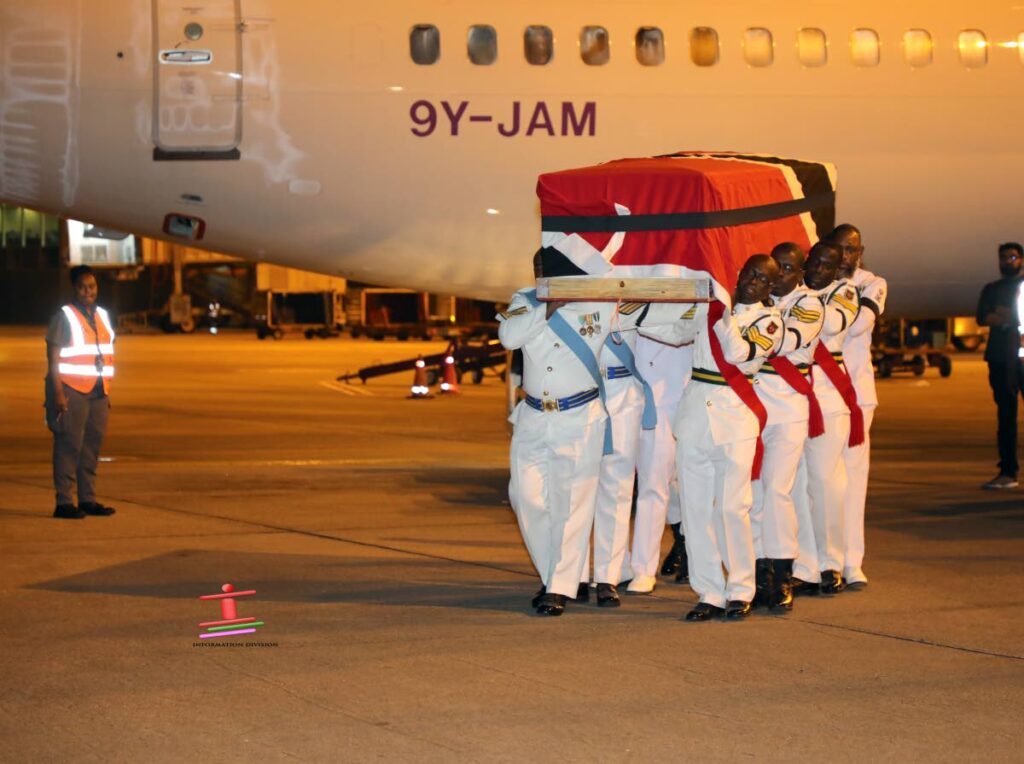 Defence Force members carry the body of former prime minister, the late Basdeo Panday which arrived on a CAL aircraft from the US at Piarco International Airport on January 3. - Government Information Division