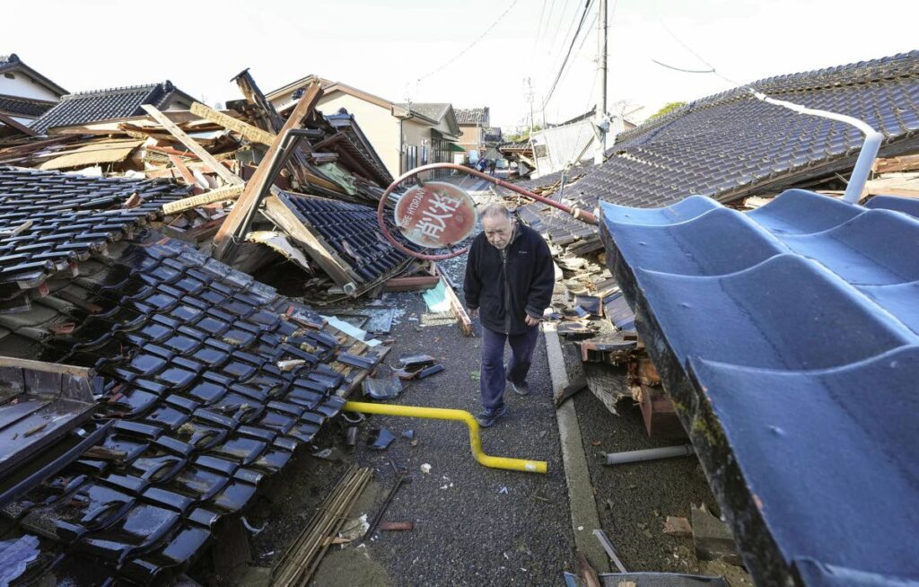 A man walks through fallen houses hit by earthquakes in Suzu, Ishikawa prefecture, Japan, on January 4, 2024. AP Photo - 
