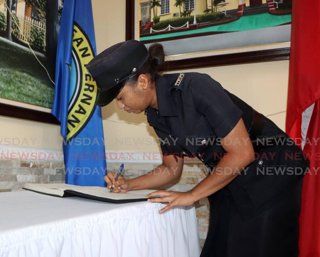 WPC Asher Khandan signs the condolence book at City Hall, San Fernando on Thursday for former prime minister Basdeo Panday, who died on January 1. - Photo by Angelo Marcelle