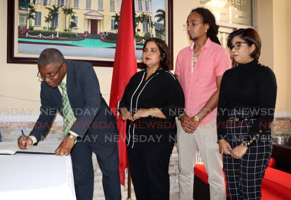 SIGNED: San Fernando mayor Robert Parris signs the condolence book opened on Thursday at City Hall in honour of former prime minister Basdeo Panday. - Photo by Angelo Marcelle