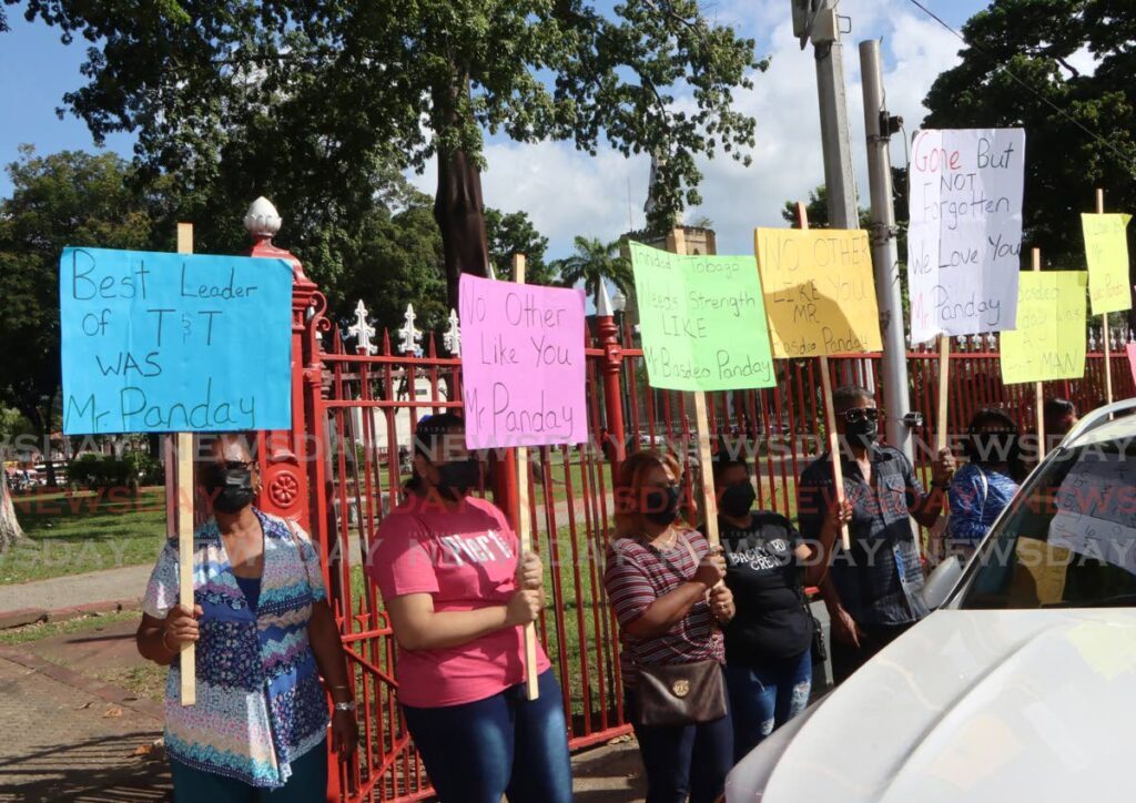 Members of the public hold signs in tribute to former prime minister the late Basdeo Panday at Woodford Square, Port of Spain, opposite the Red House where his body lay in state on January 5. - Angelo Marcelle