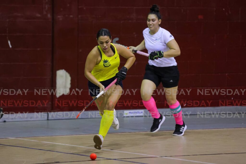 Magnolia’s Kaitlyn Olton, left, pushes forward after making a steal from GBTI GCC’s Gabriella Xavier during the Ventures Indoor Hockey International Invitational Tournament women's match at the Woodbrook Youth Facility on Friday, in Port of Spain. - DANIEL PRENTICE