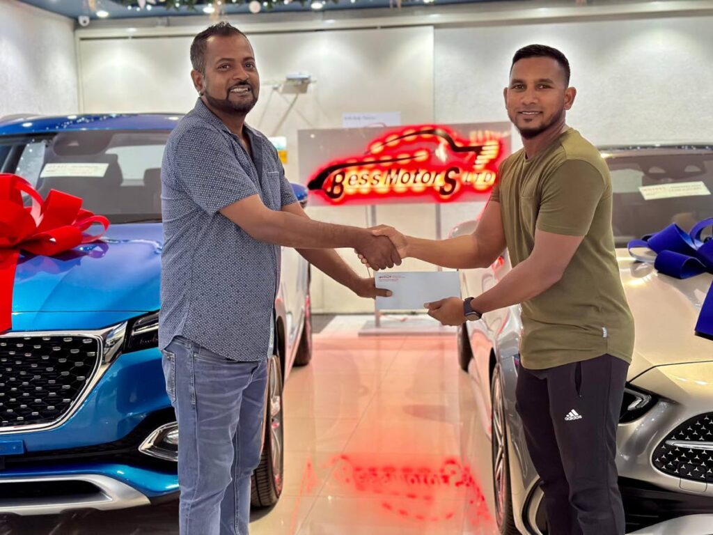 Director of Bess Motors Ltd Ian Maharaj, left, presents a cheque to president and captain of Marchin Patriots Adrian Ali. - 