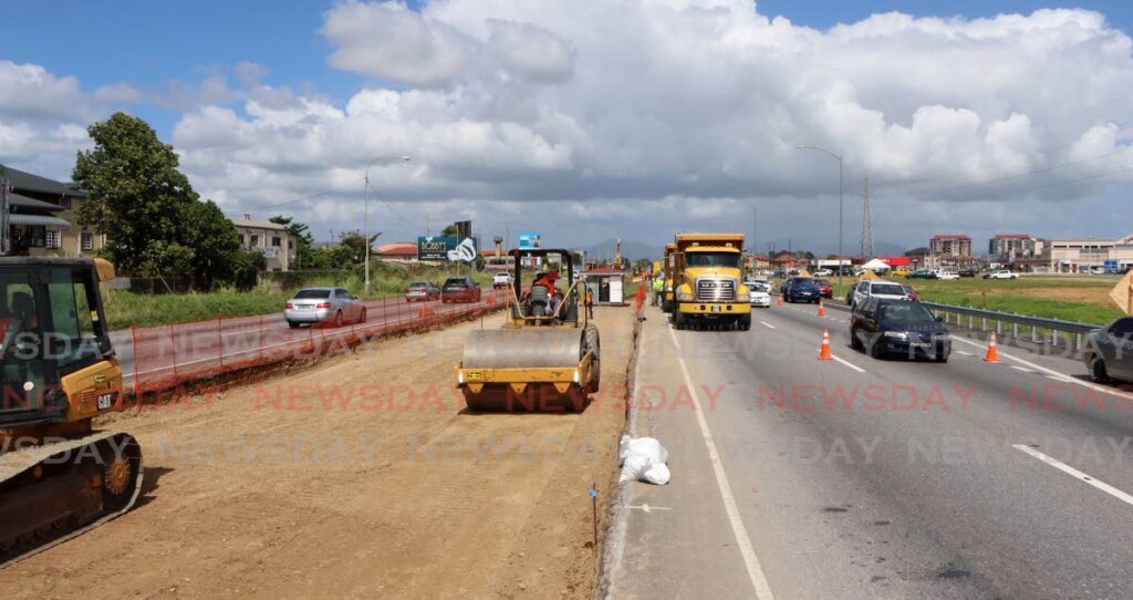 A crew from the Ministry of Works and Transport continues construction of additional lanes to the Solomon Hochoy Highway in Chaguanas on Sunday. - Photo by Angelo Marcelle